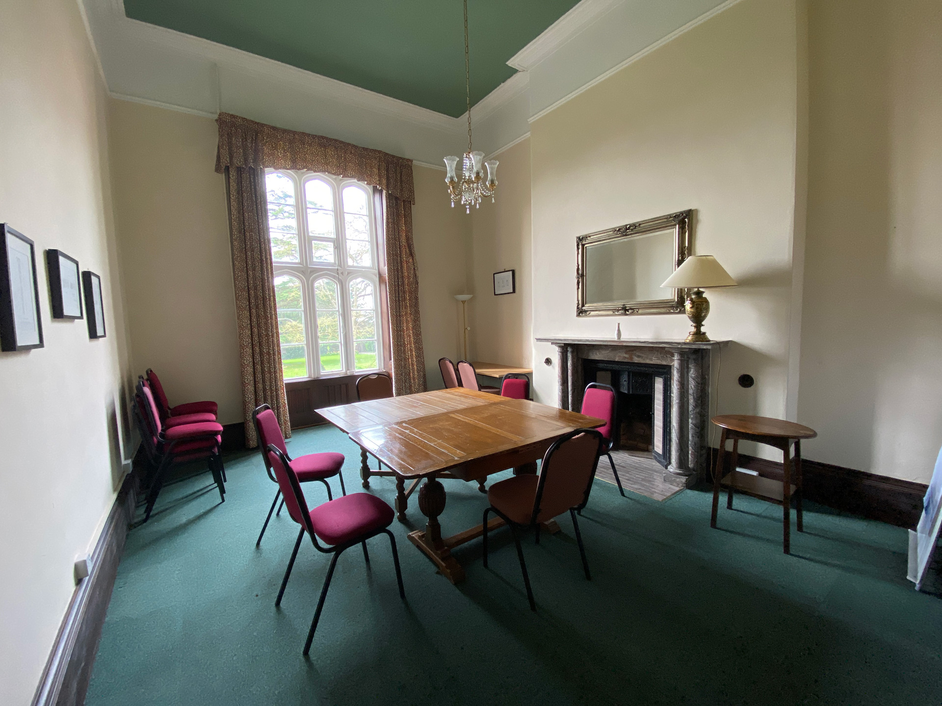 Small meeting room with table, chairs and historic fireplace